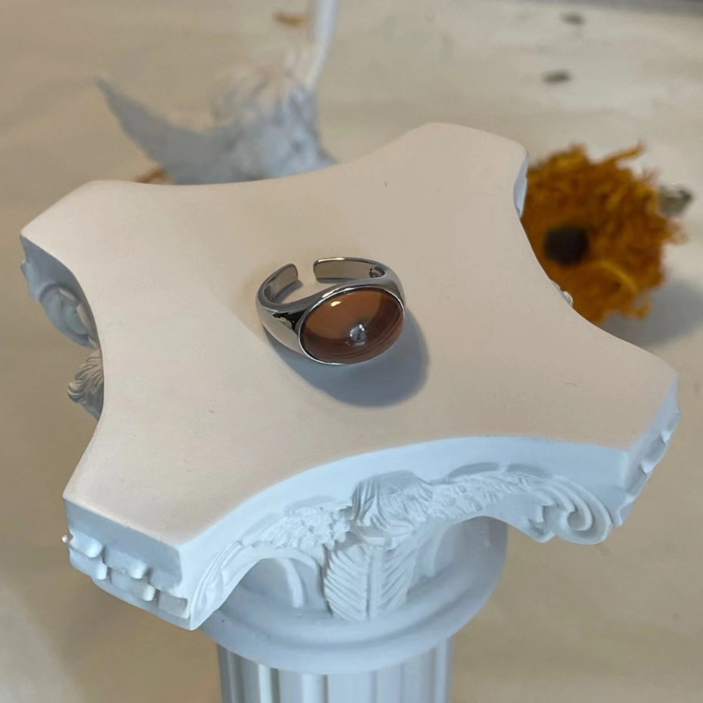 Honey jade stone alloy open ring displayed on a plaster column.
