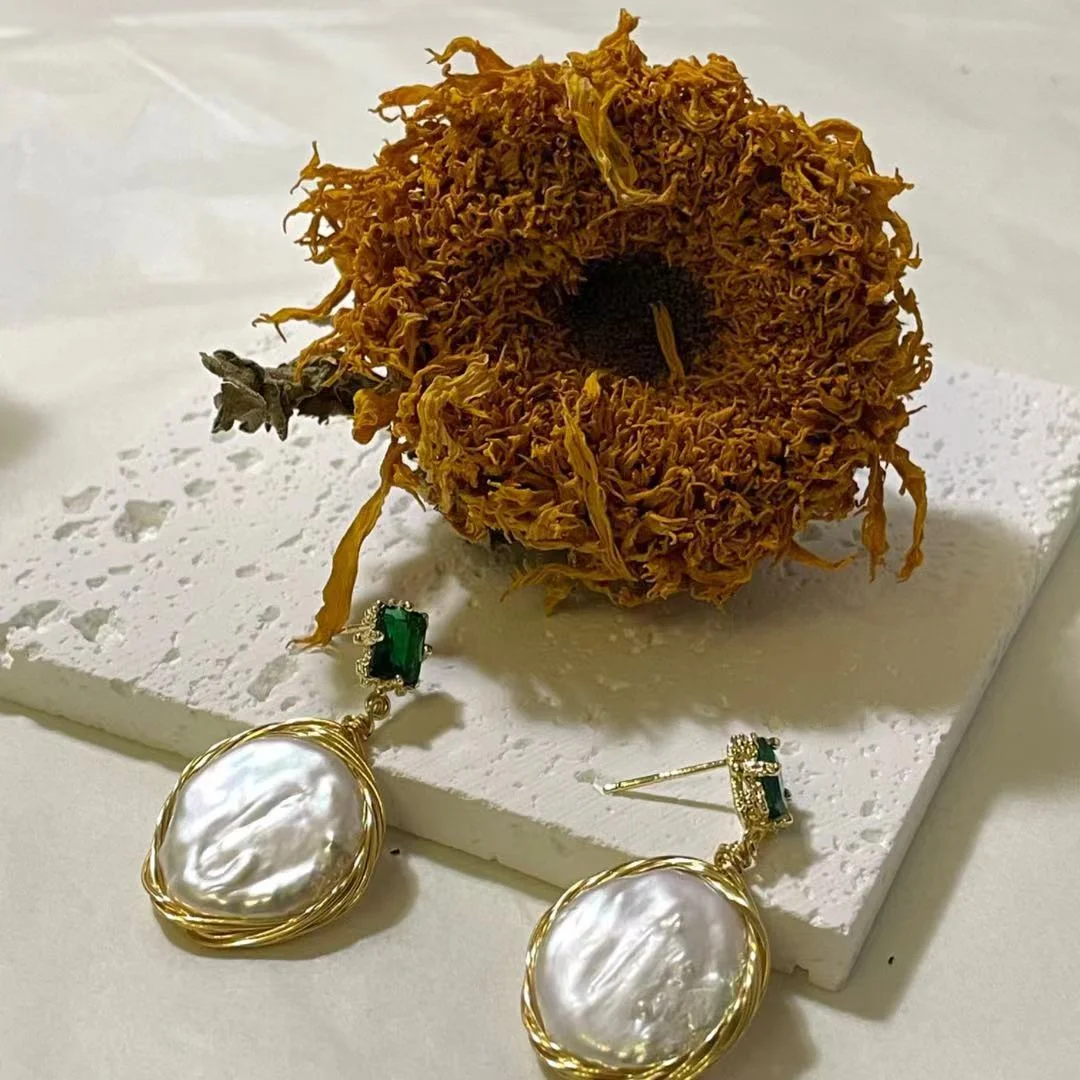 18K Gold Plated 18K Gold Plated Freshwater Pearl Baroque Drop Earrings with a dry sunflower on a white base.