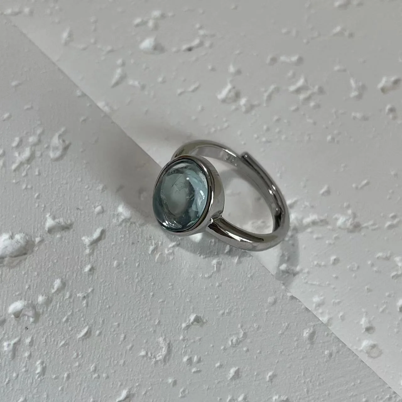 Aquamarine Silver-Plated Open Ring tilted on white base