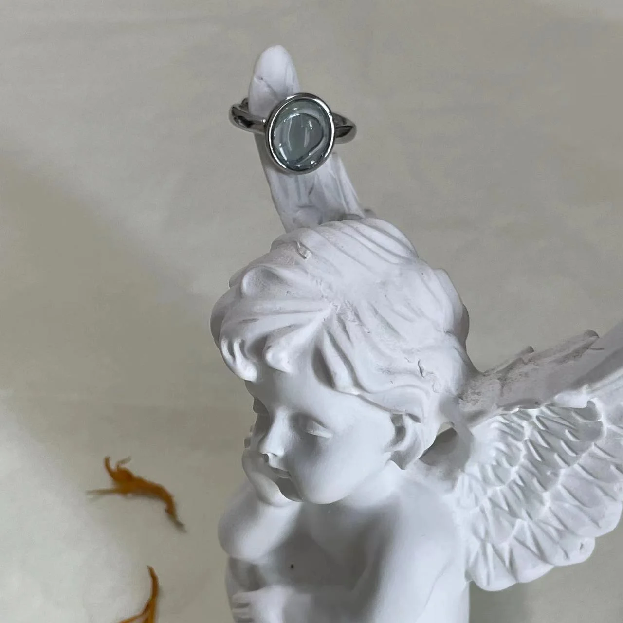 Aquamarine Silver-Plated Open Ring on plaster angel wing