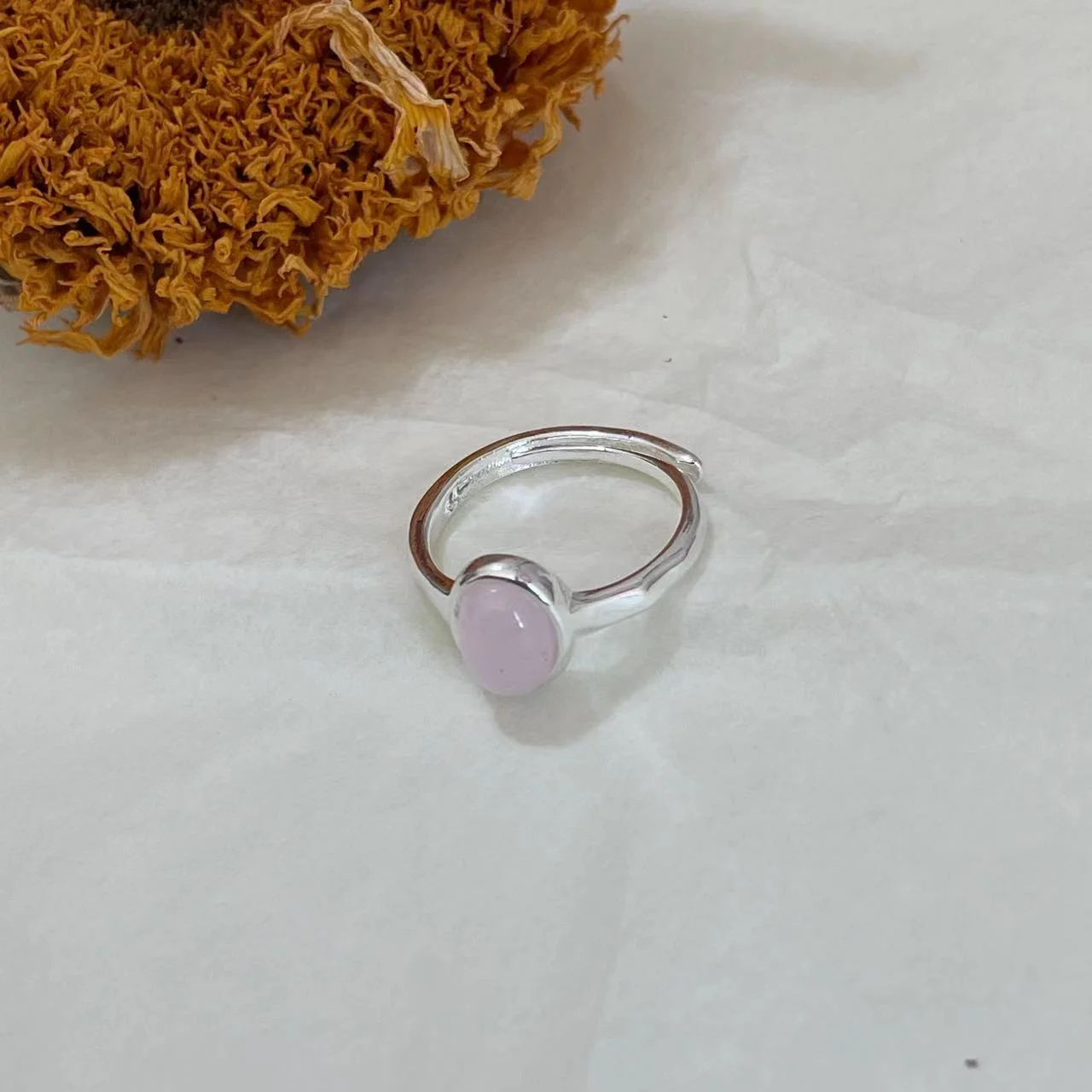 Strawberry Quartz Silver-Plated Open Ring on white fabric with dried sunflower