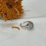 925 Sterling Silver White Topaz Ring sideways on fabric with sunflower